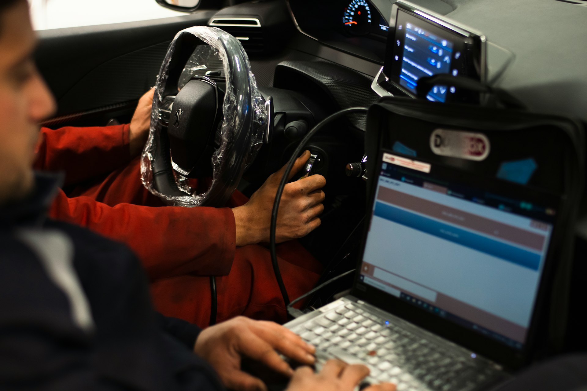A man sitting in a car using a laptop computer